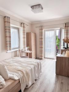 a bedroom with a large bed and two windows at Batory in Łeba