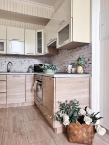 a kitchen with white cabinets and a vase of flowers at Batory in Łeba
