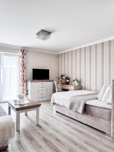 a bedroom with a bed and a couch and a tv at Batory in Łeba