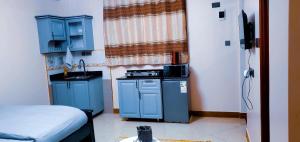 a small kitchen with blue cabinets and a sink at Ayan homes in Namulanda