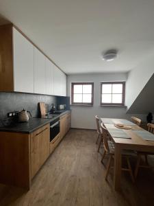 a kitchen with a table and a dining room at Apartmán Hájenka - Makov in Makov