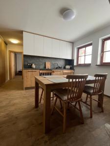 a kitchen with a table and chairs in a room at Apartmán Hájenka - Makov in Makov +9 photos