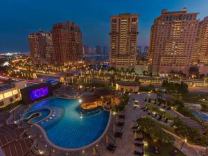 una grande piscina in una città di notte di Hilton Doha The Pearl a Doha