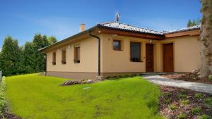 a house with a green lawn in front of it at Chalupa na Lipně - Holiday House 1 in Lipno nad Vltavou