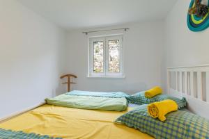 deux lits dans une chambre avec une croix sur le mur dans l'établissement Sunset, à Kustići