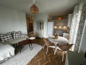 a living room with a table and chairs and a kitchen at Apartament Aleja Poetów in Chojnice