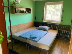 a small bed in a room with green walls at Apartmán Valtice 24 hod check in in Valtice