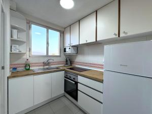 kuchnia z białymi szafkami i białą lodówką w obiekcie Coblanca 8-18º4 w mieście Benidorm