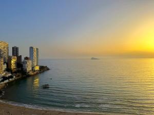 widok na miasto i ocean o zachodzie słońca w obiekcie Coblanca 8-18º4 w mieście Benidorm