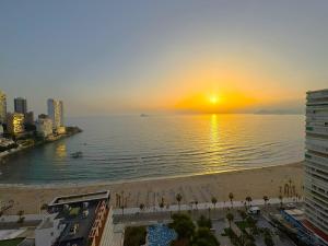 zachód słońca nad oceanem z plażą i budynkami w obiekcie Coblanca 8-18º4 w mieście Benidorm