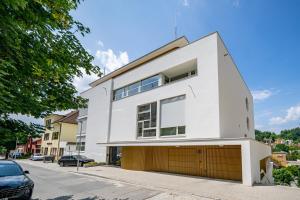 una casa blanca con garaje en una calle en Apartmán s terasou v srdci Luhačovic, en Luhačovice