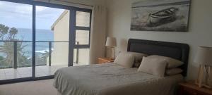 Un dormitorio con una cama con vista al mar. en Beach & Golf Escape, en Southbroom 12 fotos más
