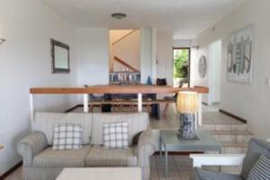 una sala de estar con un sofá y una mesa en Beach & Golf Escape, en Southbroom