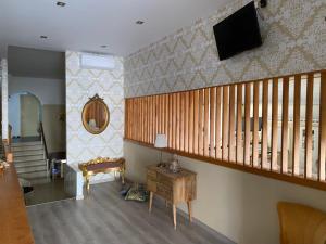 a living room with a staircase and a tv on the wall at Hotel Liberty 1 in Agia Marina Aegina