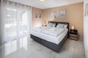 a bedroom with a large bed and a large window at Blue Sky Flat, Apartment, 73qm, 4-6 Personen, Neubau Süd-Balkon mit Lounge-Möbeln, Schwarzwald-PLUS inkl 80 Gratis-Attraktionen täglich in Baiersbronn