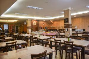a restaurant with wooden tables and chairs and a clock at Pousada e Restaurante Del Miro in Nova Pádua