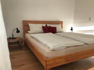a bedroom with a large wooden bed with red pillows at Ferienwohnung-Bosau-im-Schwedenhaus in Bosau