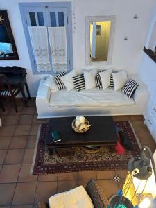 a living room with a white couch and a table at Serifos house in Serifos Chora +1 photo