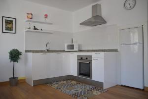a white kitchen with a stove and a microwave at Pepe Pastora in Arroes