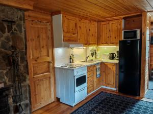 a kitchen with a stove and a refrigerator at Kivakko Saariselän paratiisi - Oma ranta & sauna in Saariselka +30 photos