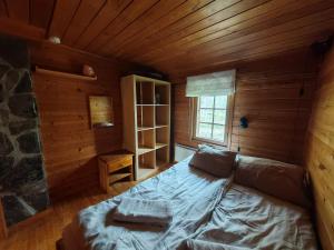 a room with a bed in a wooden cabin at Kivakko Saariselän paratiisi - Oma ranta & sauna in Saariselka