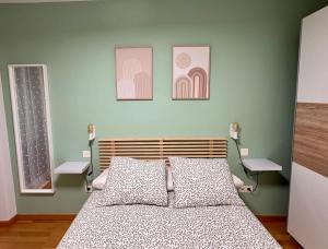ein Schlafzimmer mit einem Bett und drei Bildern an der Wand in der Unterkunft Apartamento Blesino in Saragossa