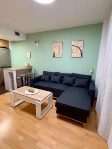 ein Wohnzimmer mit einem blauen Sofa und einem Tisch in der Unterkunft Apartamento Blesino in Saragossa
