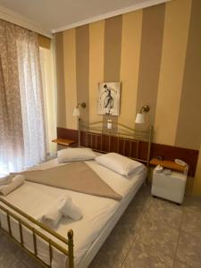 a bedroom with two beds and a striped wall at Hotel Liberty 1 in Agia Marina Aegina