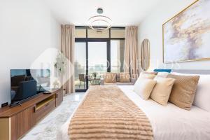 Bloomfield's VistaVibe Stu Al Maryah Island في أبوظبي: غرفة نوم مع سرير كبير وتلفزيون +9 صور