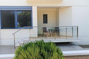 a balcony of a house with a table and chairs at Fyki Salty Studio in Áyioi
