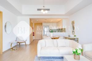un salon avec un canapé blanc et une table dans l'établissement Bloomfields Cozy 1br Mayan with Beach Access, à Abu Dhabi 8 autres photos