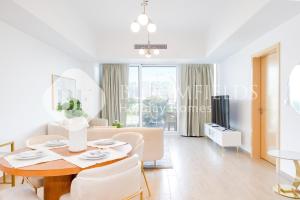 un salon blanc avec une table et des chaises dans l'établissement Bloomfields Cozy 1br Mayan with Beach Access, à Abu Dhabi