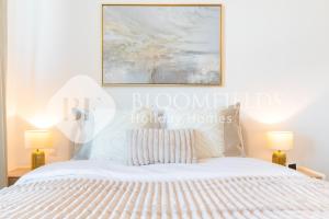 une chambre avec un lit blanc et deux lampes dans l'établissement Bloomfields Cozy 1br Mayan with Beach Access, à Abu Dhabi