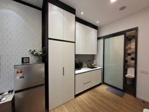 a kitchen with white cabinets and a stainless steel refrigerator at Ceylonz Suites By ANA MALAYSIA in Kuala Lumpur +50 photos