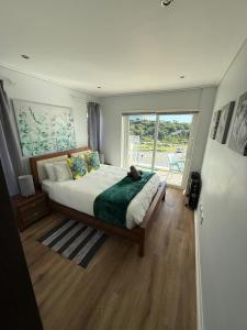 a bedroom with a large bed and a large window at Seaside Rainbow Retreat At The Pearls #inverter in Summerstrand