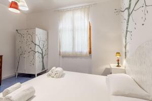 Un dormitorio blanco con una cama y una ventana. en Nura's - Villa Verde Guest House, en Alghero