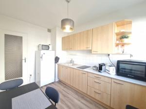 a kitchen with wooden cabinets and a white refrigerator at Les Peupliers #Parking in Chamalières