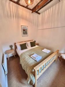 a bedroom with a large bed with two towels on it at One Threadneedle Street, Dedham in Dedham