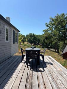 a table and chairs sitting on a wooden deck at Camp Les Deux in Jouillat