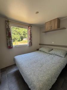 a bedroom with a large bed and a window at Camp Les Deux in Jouillat