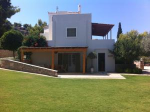 a small white house with a grass yard at Xenon Estate in Spetses