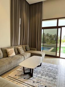 Una sala de estar con un sofá y una mesa de café. en Hawana Salalah, en Salalah 9 fotos más