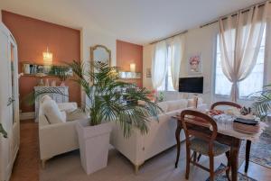 a living room with a couch and a table with a plant at La Maison B - L'auberge autonome au charme vintage in Bergerac