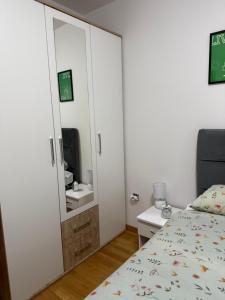 a small bedroom with a bed and a mirror at Nur Bulevar in Sarajevo +30 photos