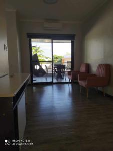 Una sala de estar con un sofá y sillas y una mesa. en Defaris Apartments, en Dargai