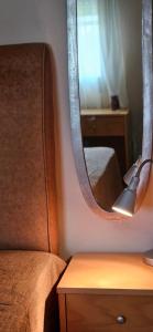 1 dormitorio con espejo, cama y mesa en Ampeli Garden, en Afitos
