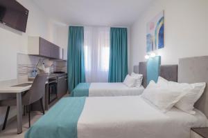 a hotel room with two beds and a kitchen at AS APARTMANI PIROT in Pirot