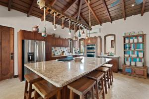 une cuisine avec un grand îlot et des placards en bois dans l'établissement Las Catalinas Villa 5 BD, à Playa Danta