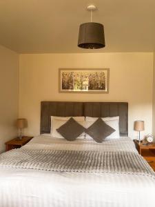 a bedroom with a large white bed with two lamps at Westminster College Cottages, Cambridge in Cambridge