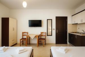 a room with a kitchen and a table with chairs at Villa Zeka Ksamil in Ksamil +32 photos